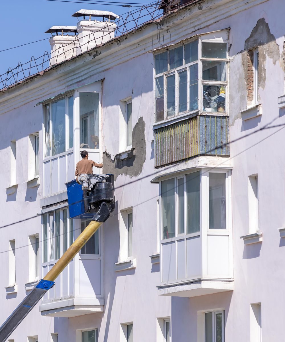 Maler arbeitet an einer Hausfassade